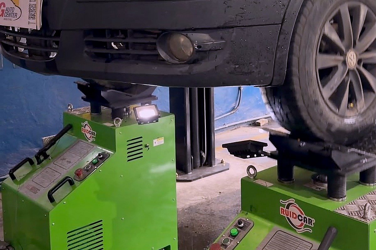 Equipamento RuidCar em uso na JG Auto Center, com veículo elevado para diagnóstico de ruídos